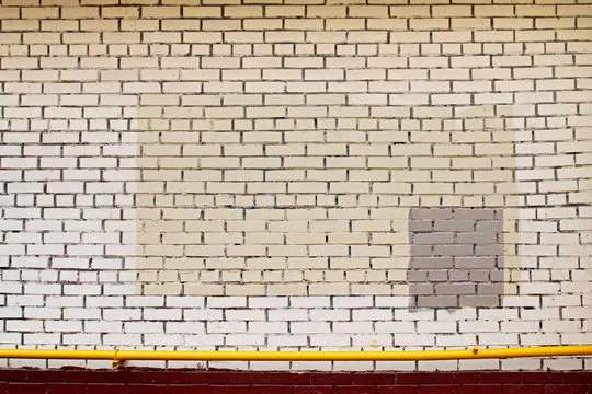Colorful (yellow, beige, grey) painted wall with yellow pipe as background, texture