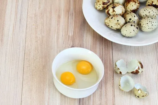 Raw partridge eggs in white bowl /  Quail spotted eggs  on white plate  and partrige shells