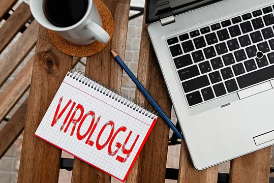 Writing note showing Virology. Business concept for branch of science dealing with the variety of viral agents and disease Workplace overview with laptop used for individual interest